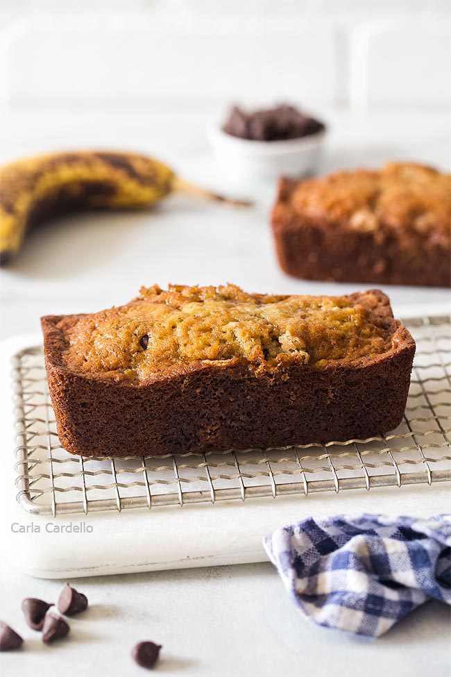 Two mini banana bread loaves on a cutting board