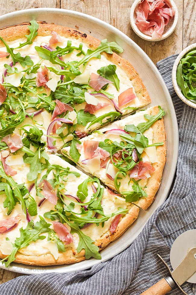 Slice cut out of prosciutto arugula pizza