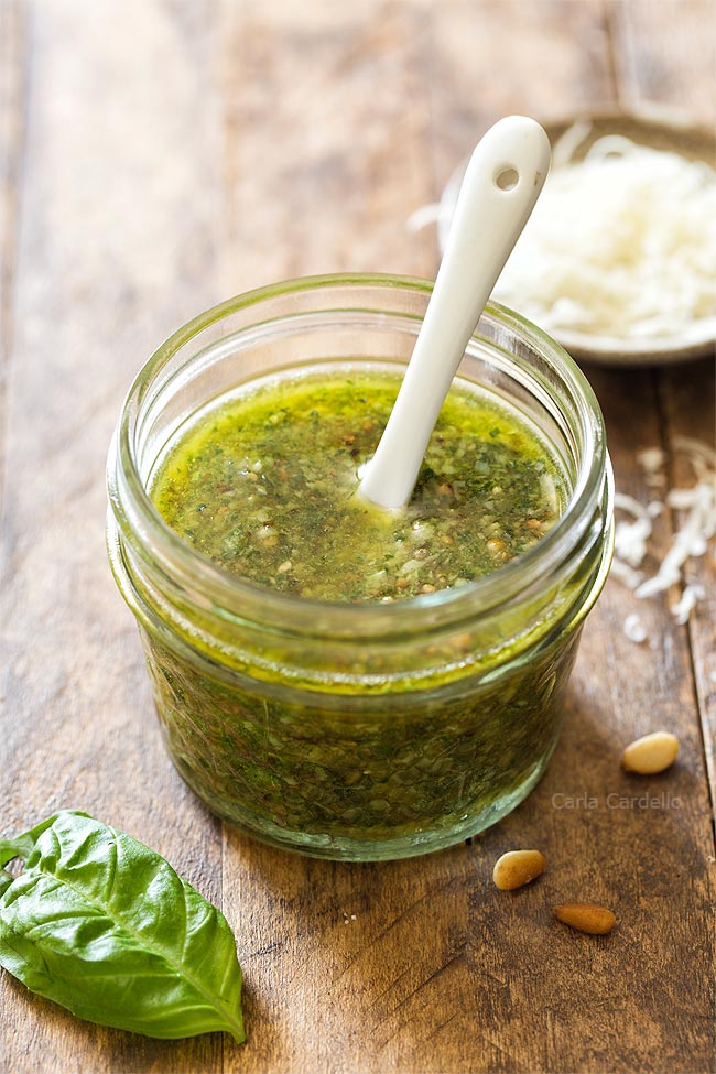 Basil pesto in small jar with white spoon