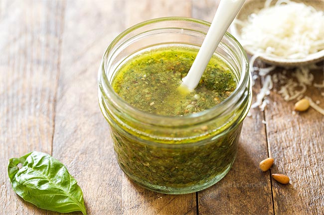 Basil pesto in small jar with white spoon
