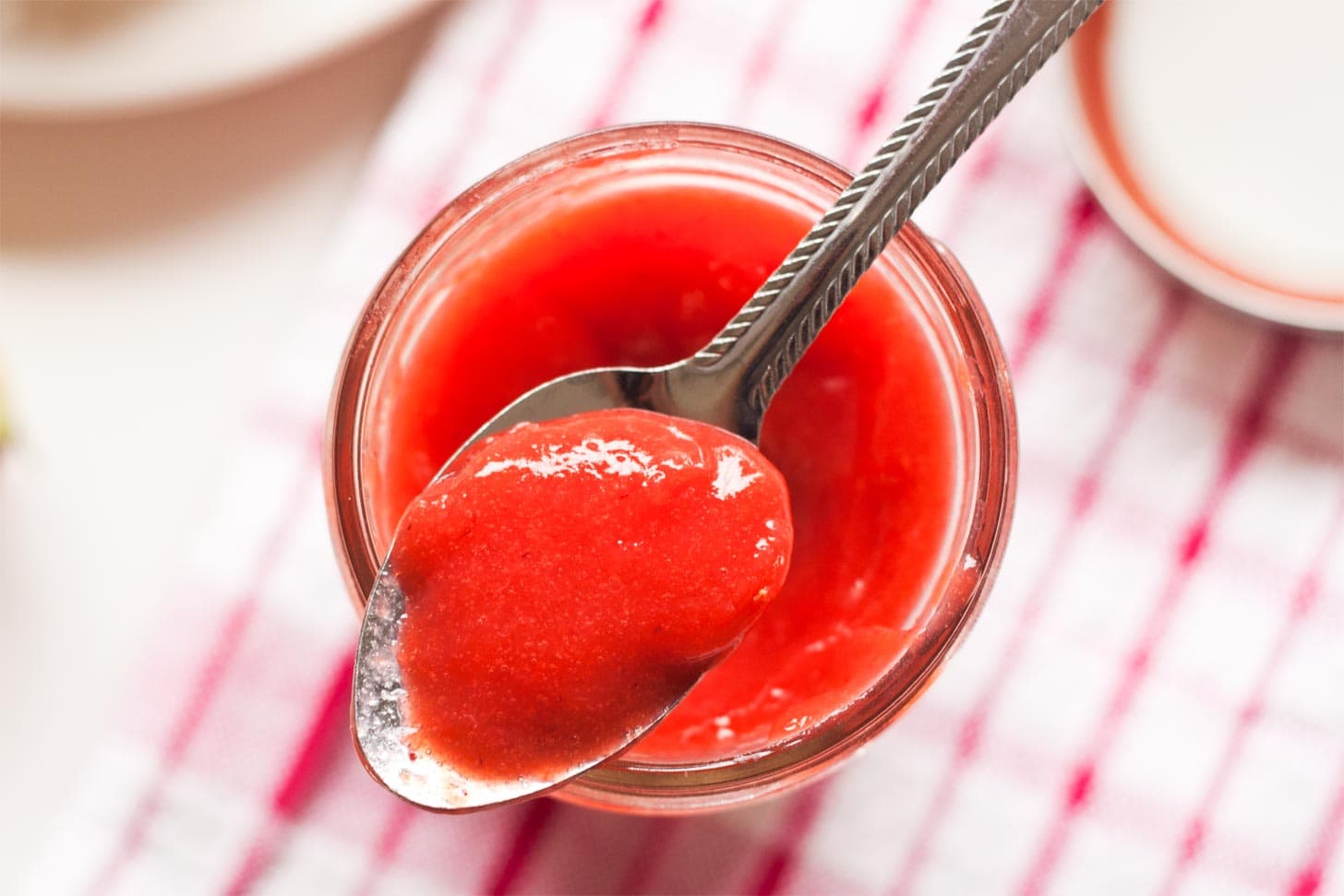 Jar of strawberry curd with spoon
