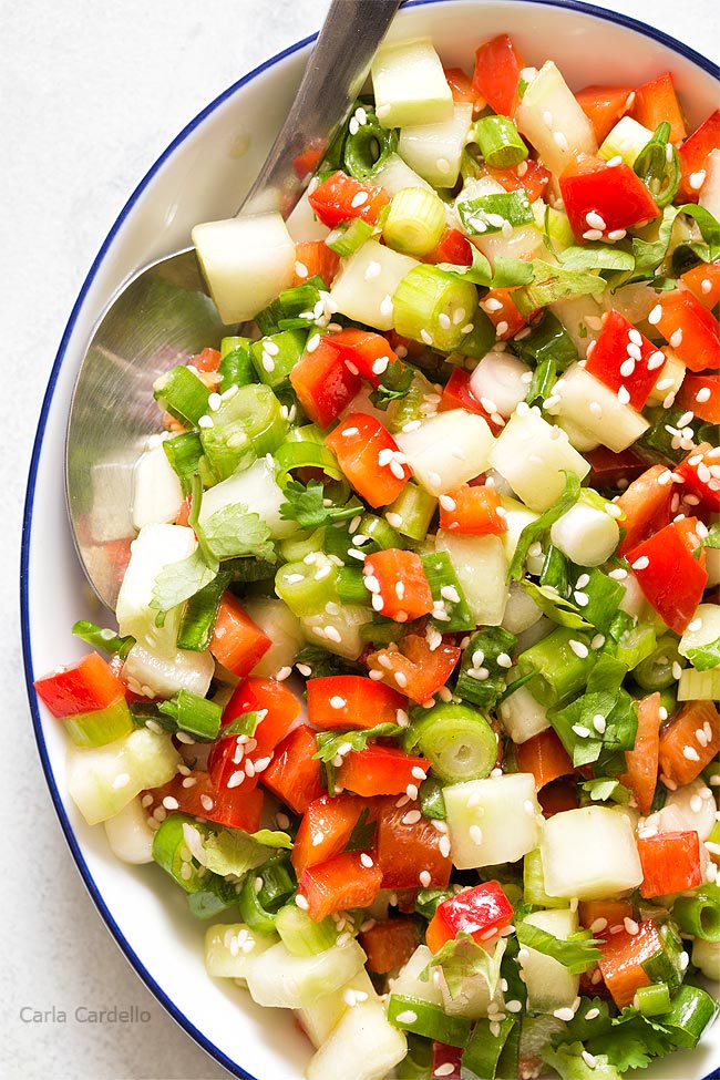 Close up of white bowl filled with green onion salad