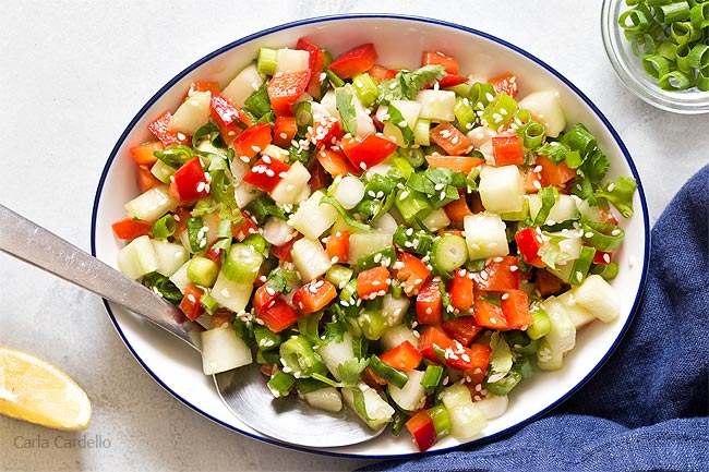 White bowl filled with green onion salad