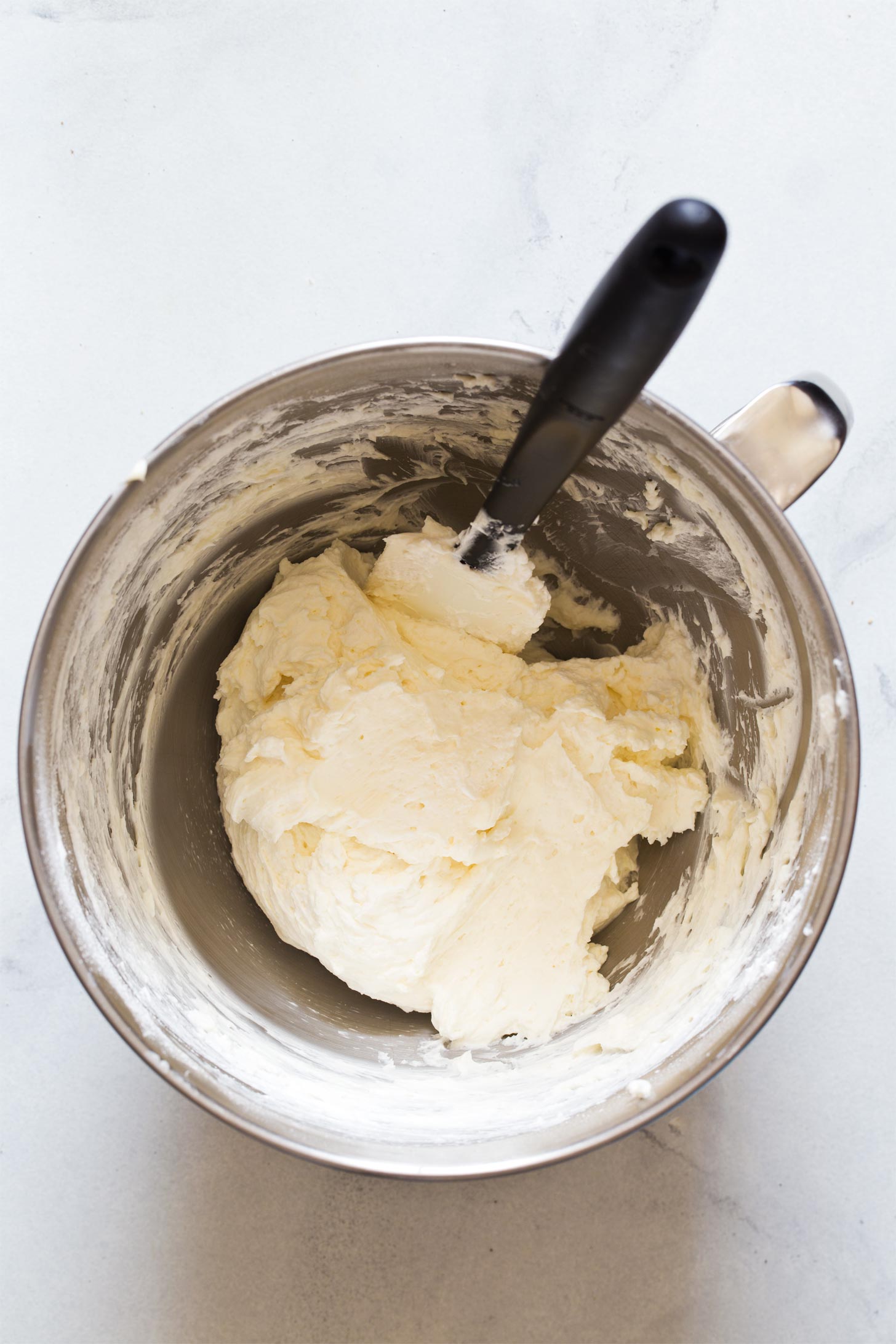 Folding whipped cream into cream cheese mixture for making no bake cheesecake