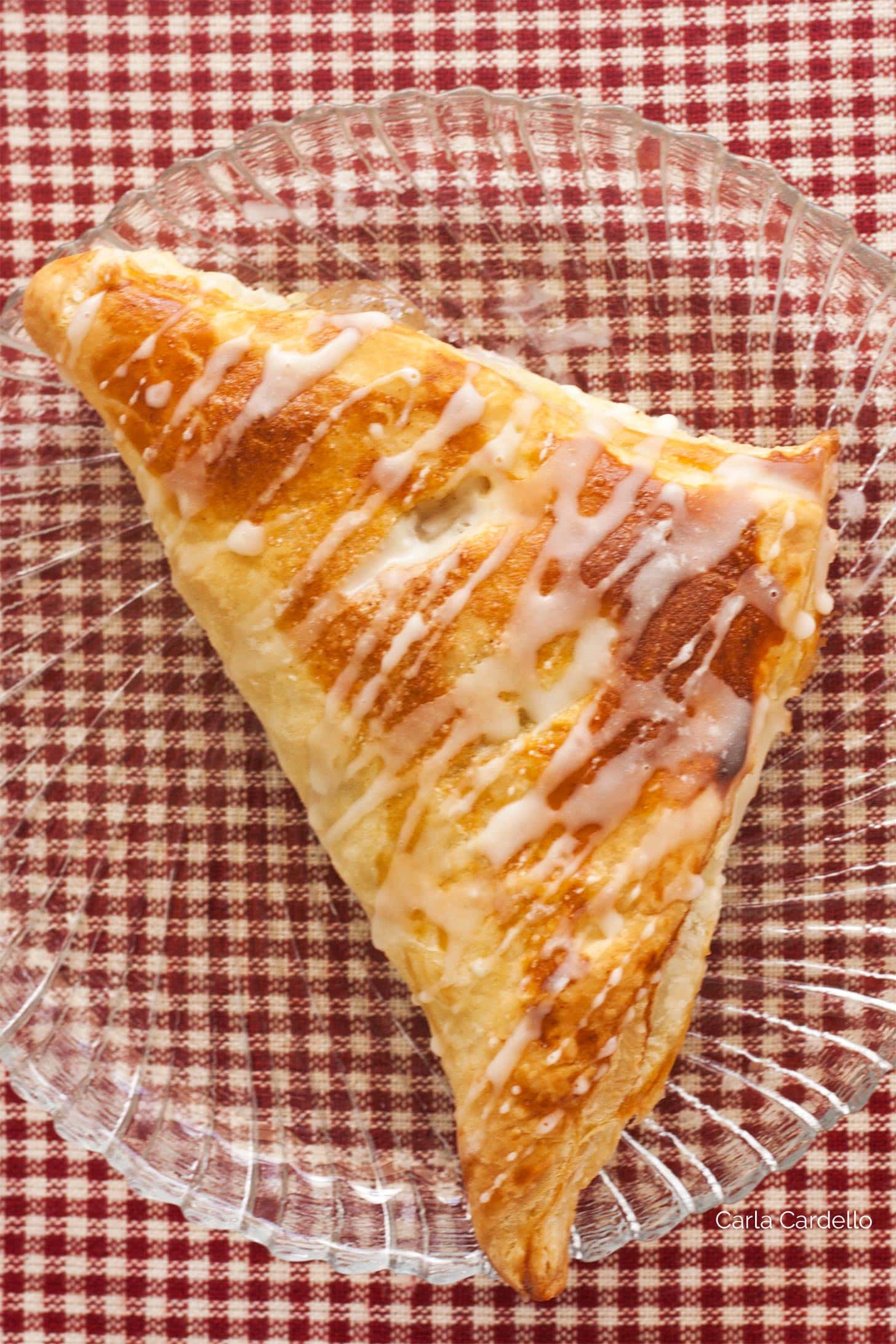 Single puff pastry apple turnover on a clear plate
