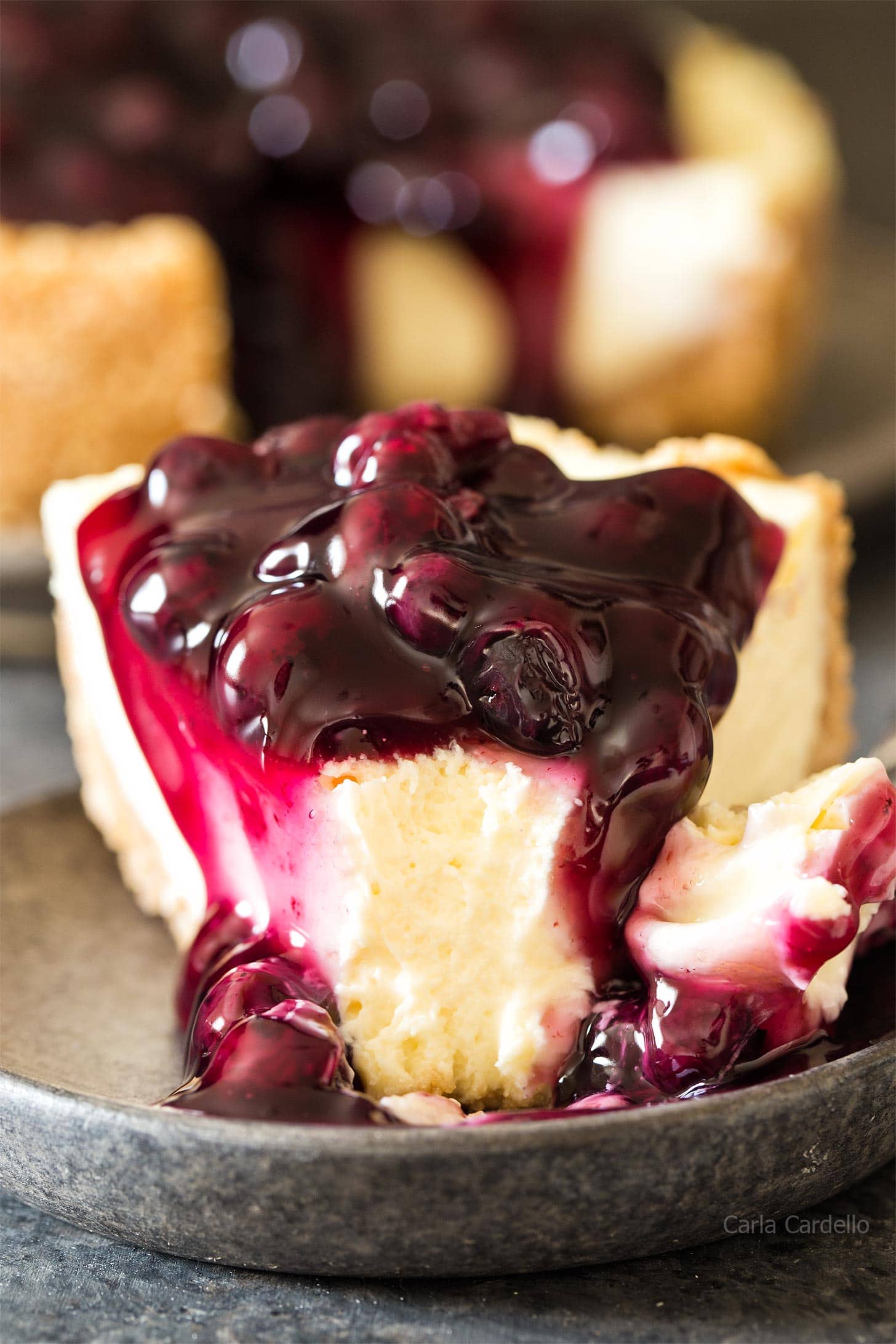 Slice of 7 inch cheesecake with blueberry pie filling