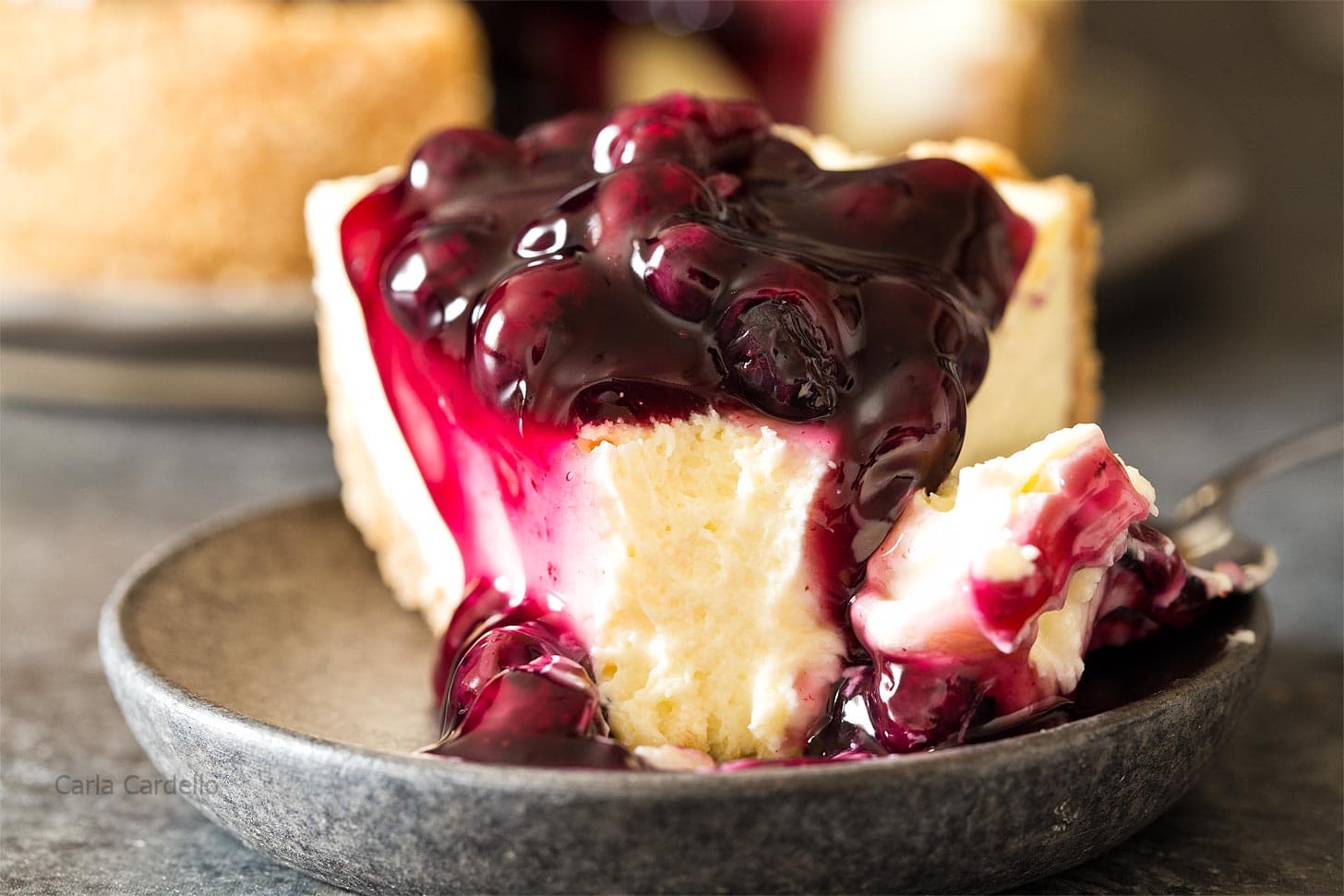 Slice of 7 inch cheesecake with blueberry pie filling