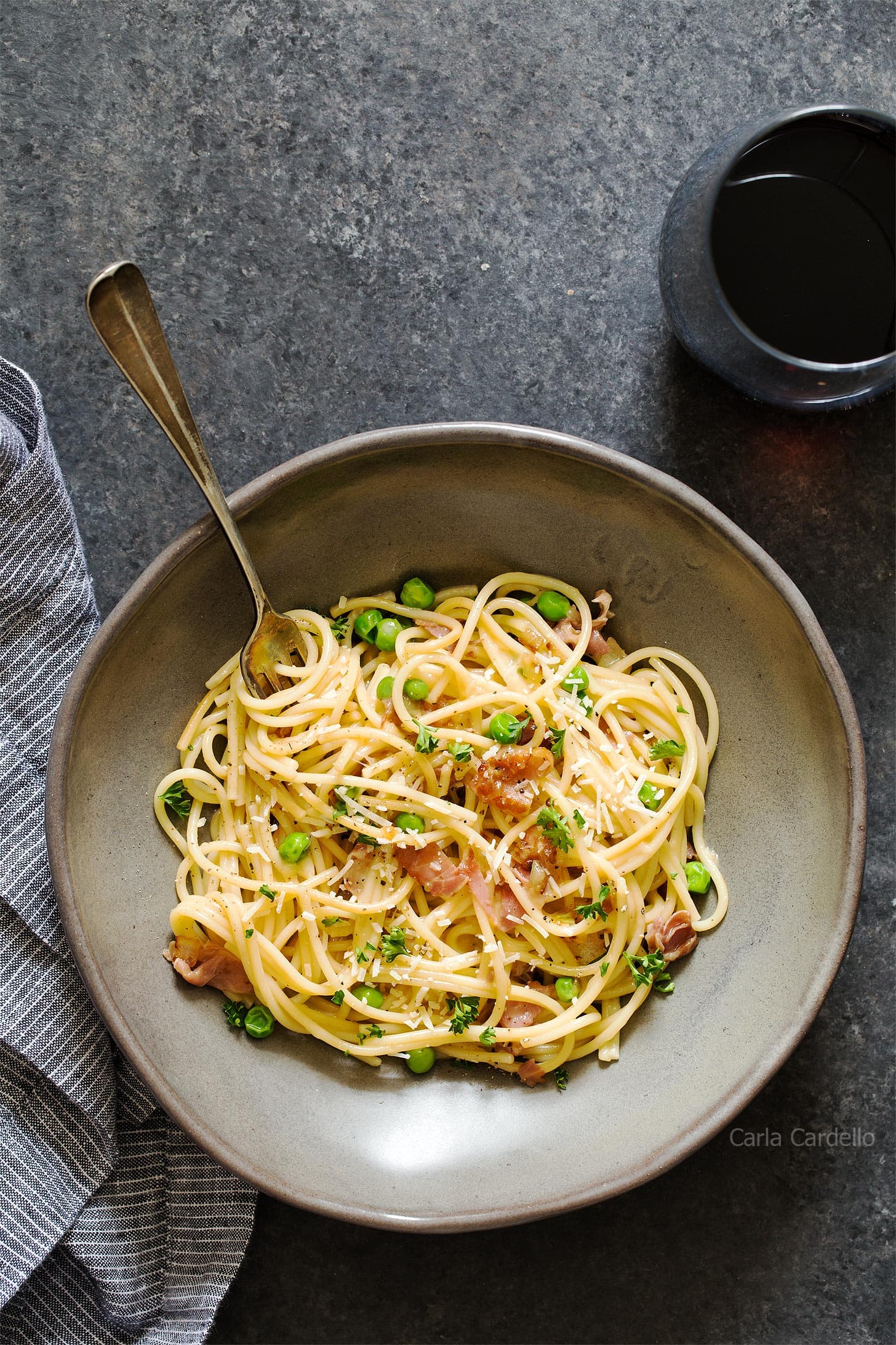 Prosciutto pasta in grey bowl with fork