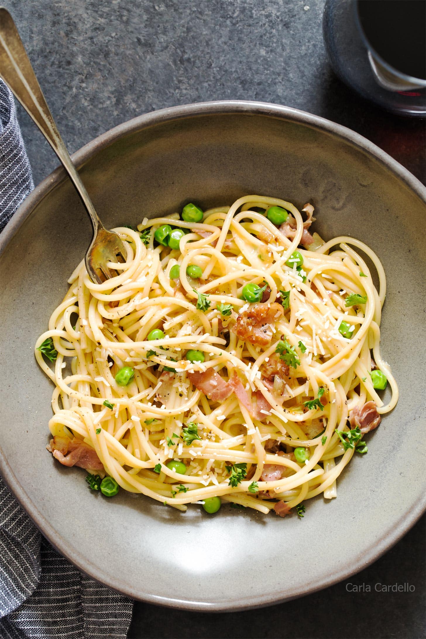 Close up of prosciutto pasta in grey bowl with fork