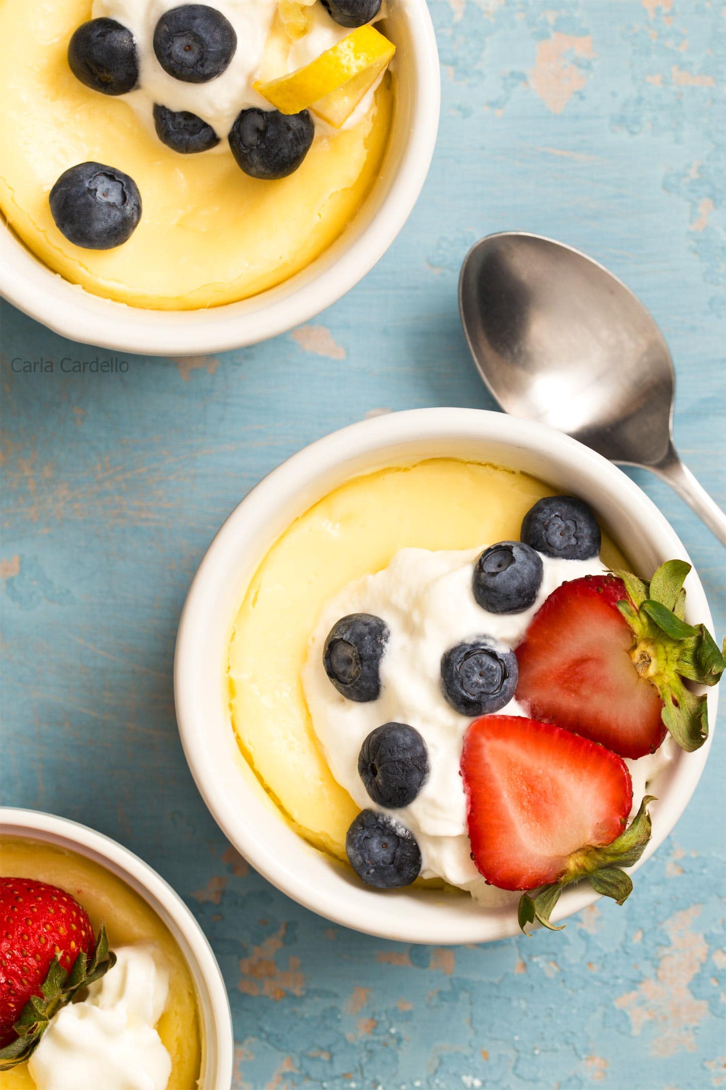 Air Fryer Cheesecake in ramekins with whipped cream and berries