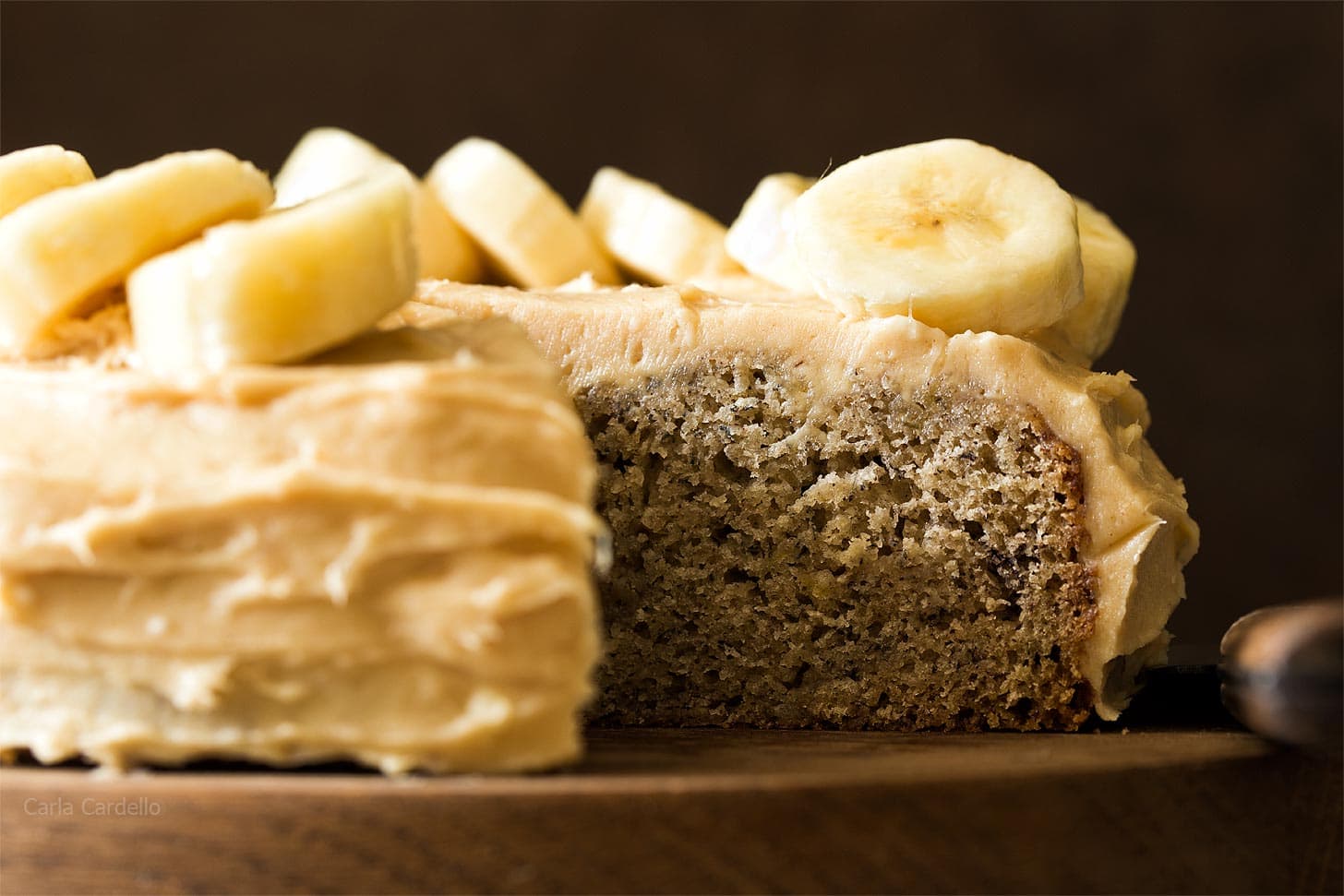Close up of Small Banana Cake on wooden board with slice cut out