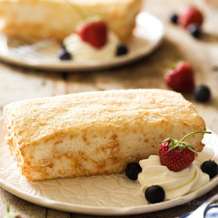 Mini Angel Food Cake on white plate with whipped cream and berries