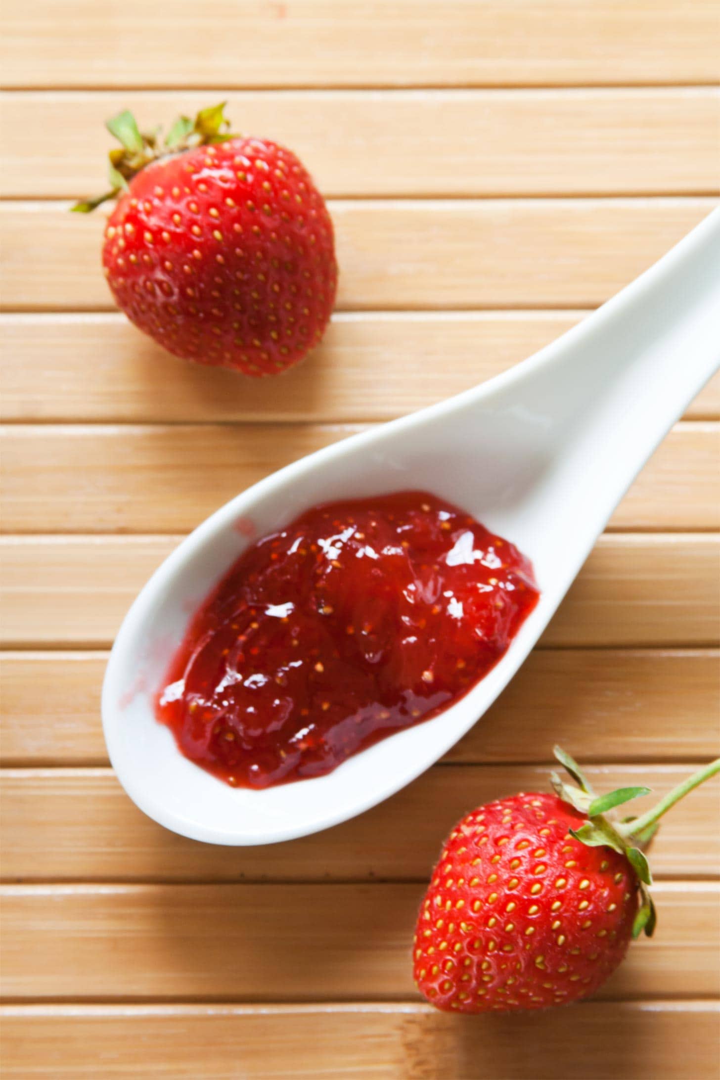 Homemade strawberry jam on white spoon