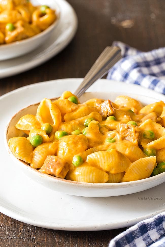 White bowl of pumpkin mac and cheese on a white plate