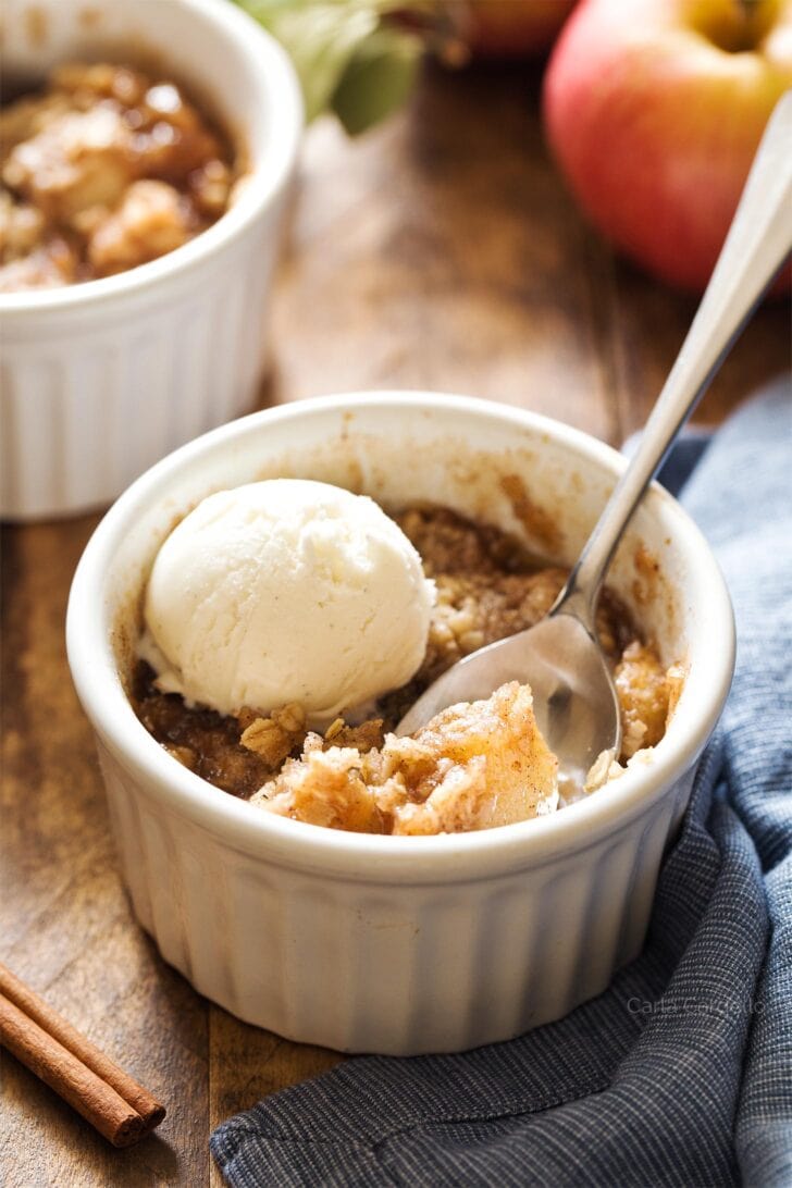 Apple crisp in white ramekin with spoon