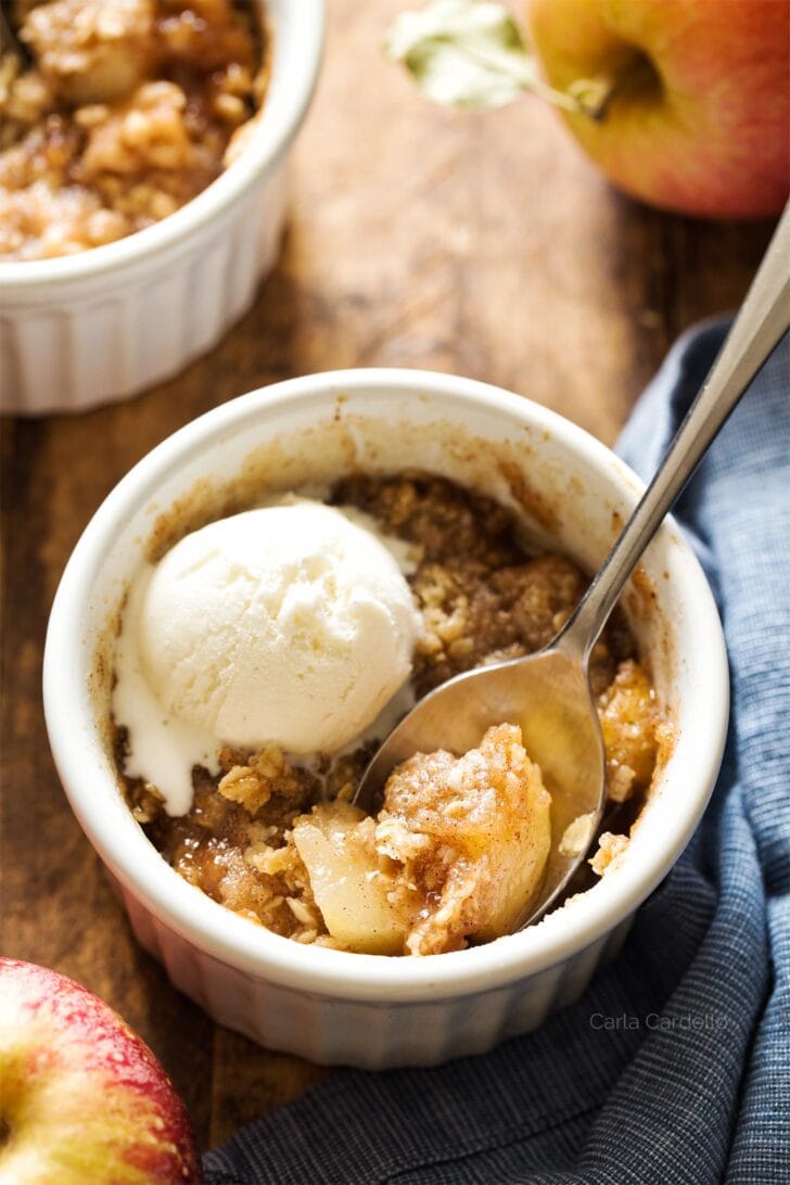 Apple crisp in white ramekin with spoon