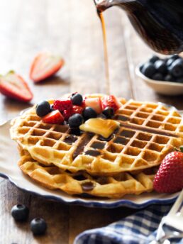 Pouring syrup on top of waffles for two
