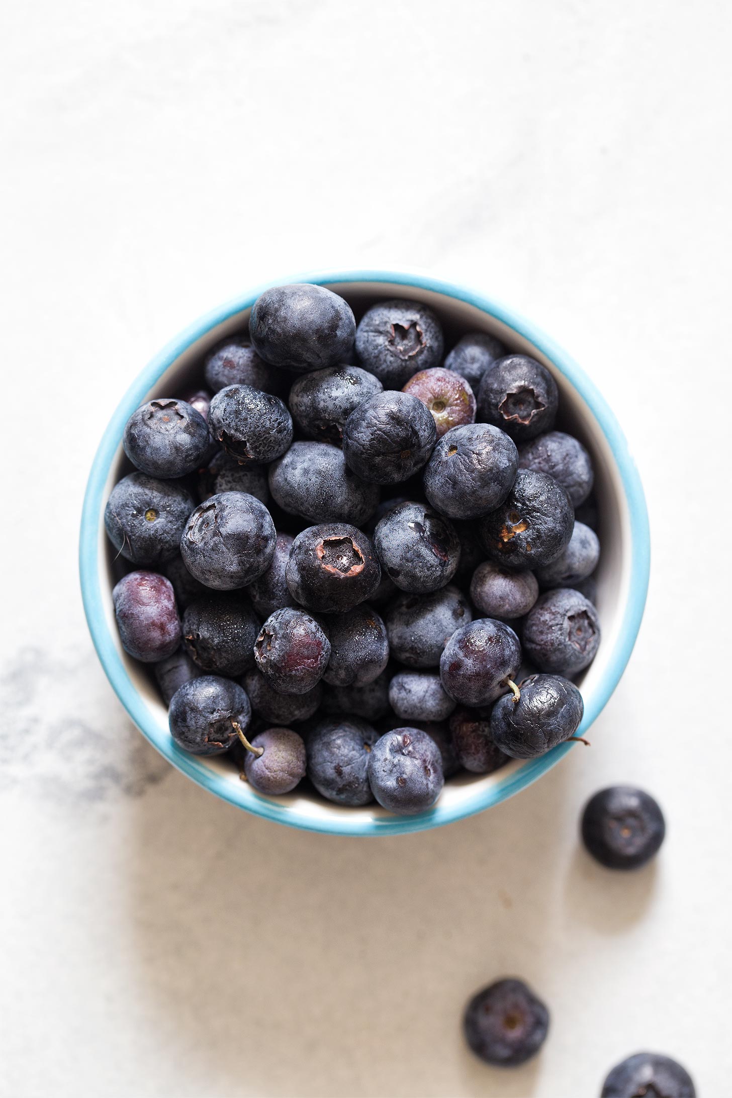 Fresh blueberries in a small white bowl