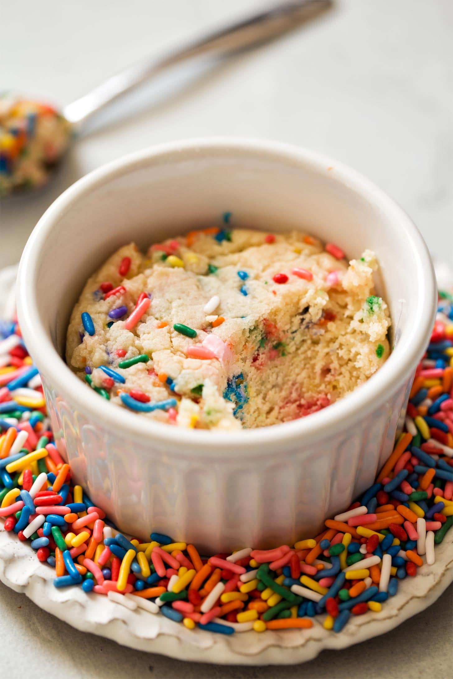 Sugar Cookie in a ramekin on a plate of sprinkles