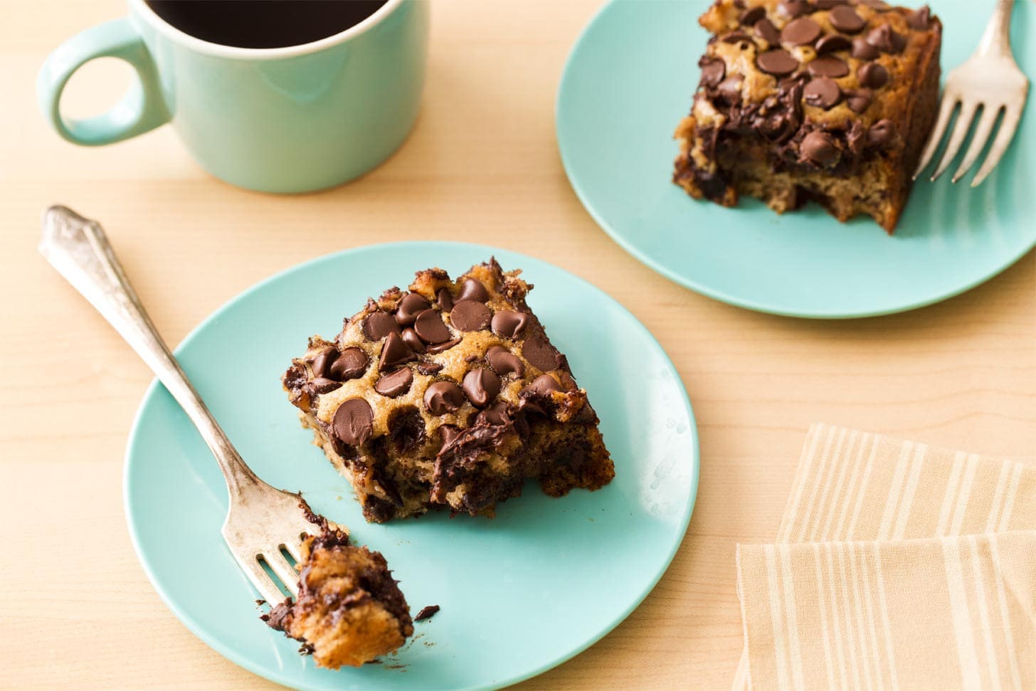 Two slices banana chocolate chip cake on blue plates