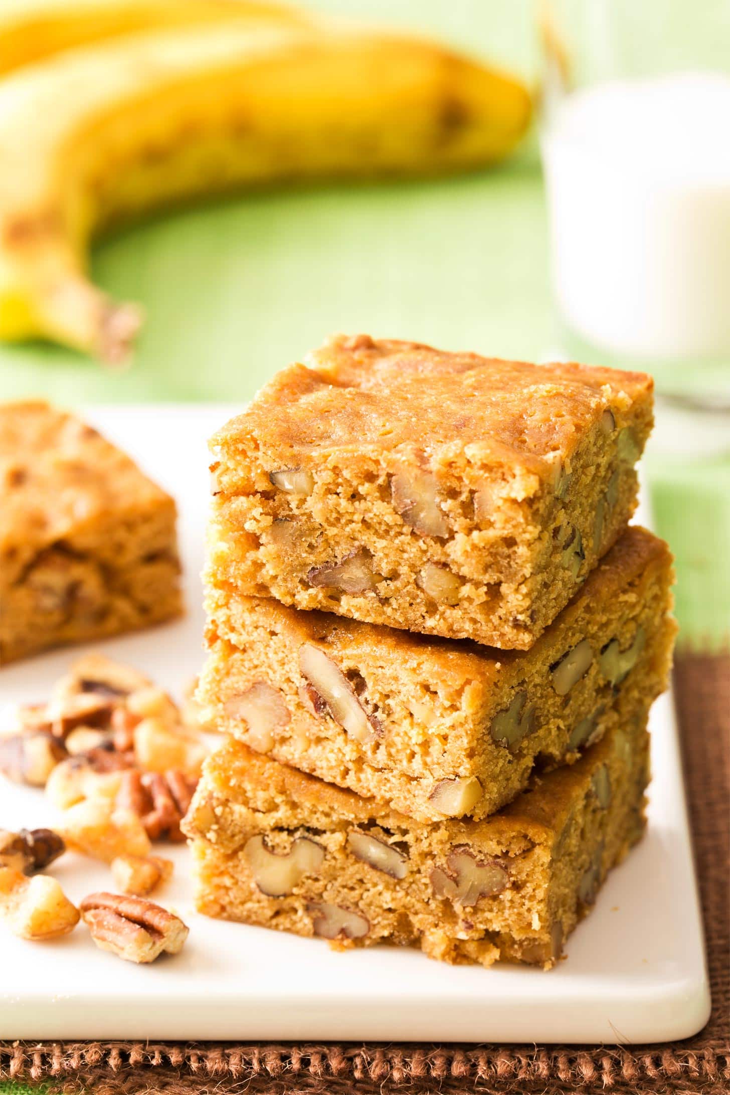 Banana Blondies stacked on a white cutting board