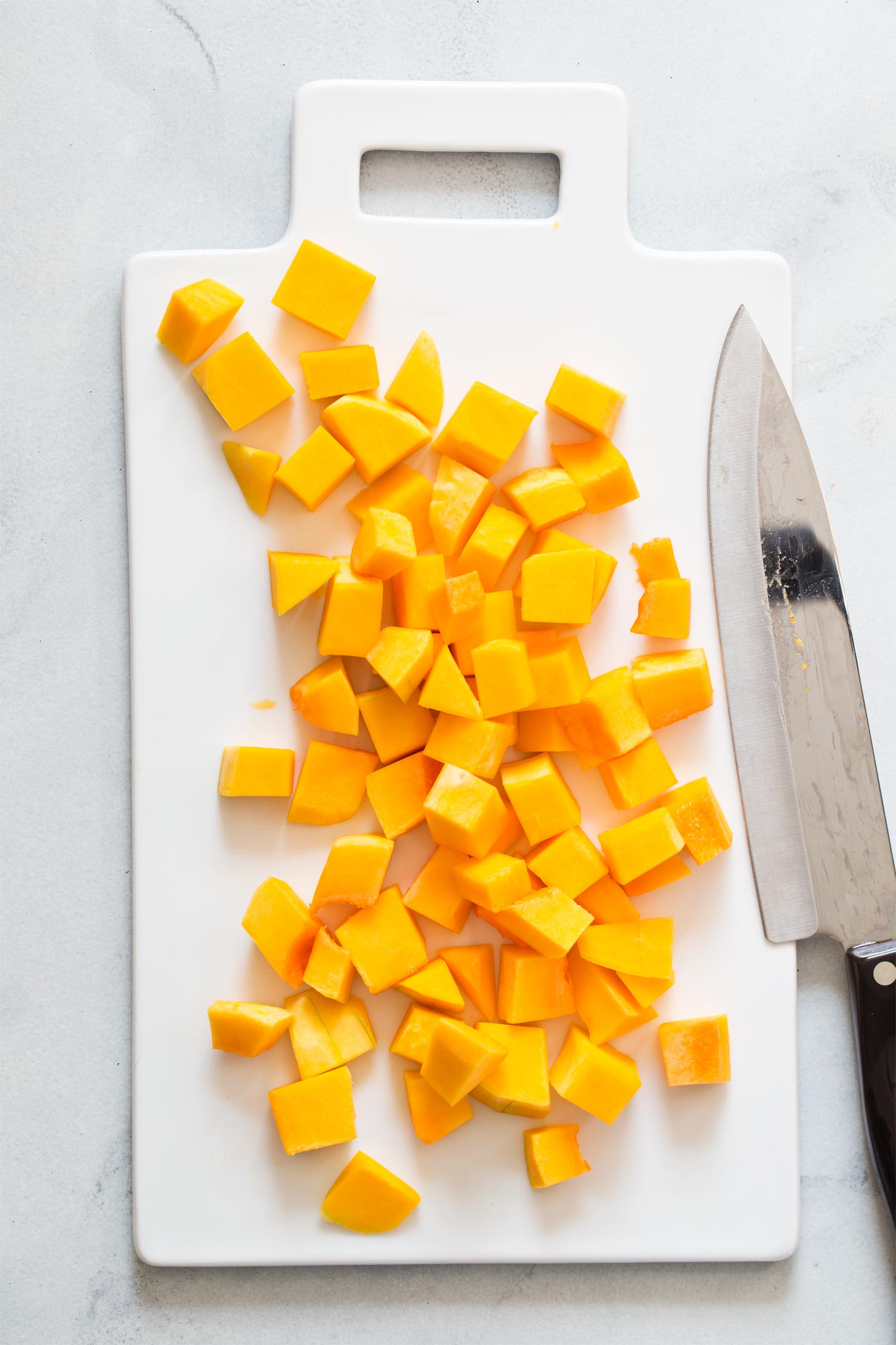 Cutting butternut squash into cubes for roasting