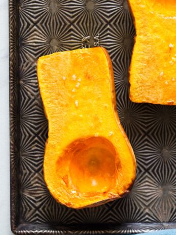 Close up of roasted butternut squash halves on a baking tray