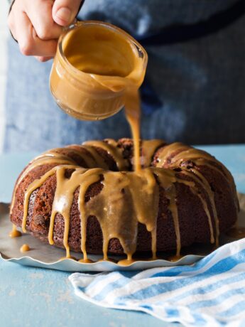 Drizzling caramel glaze over chocolate bundt cake