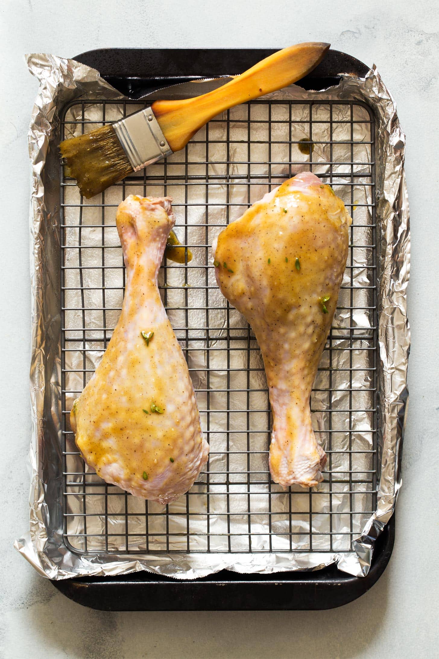 Brushing turkey drumsticks with mustard glaze