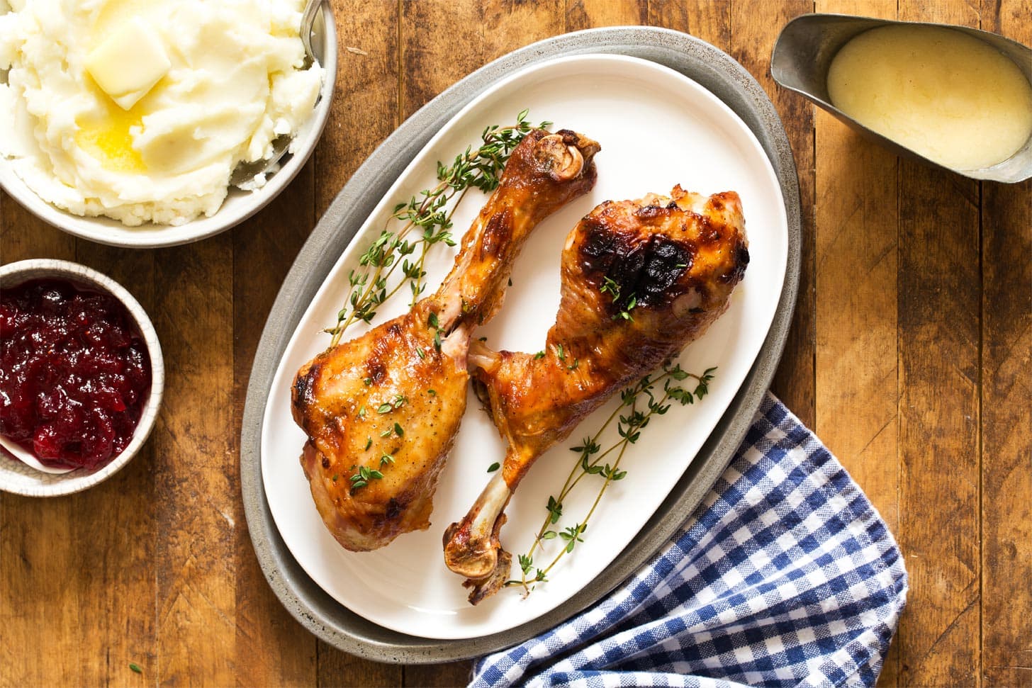 Roasted turkey drumsticks on white platter