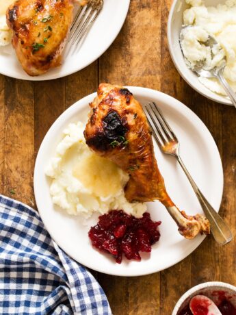 Roasted turkey legs served with mashed potatoes, gravy, and cranberry sauce