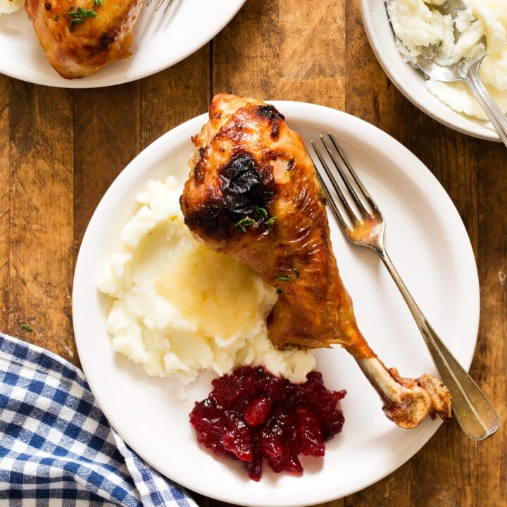 Roasted turkey legs served with mashed potatoes, gravy, and cranberry sauce