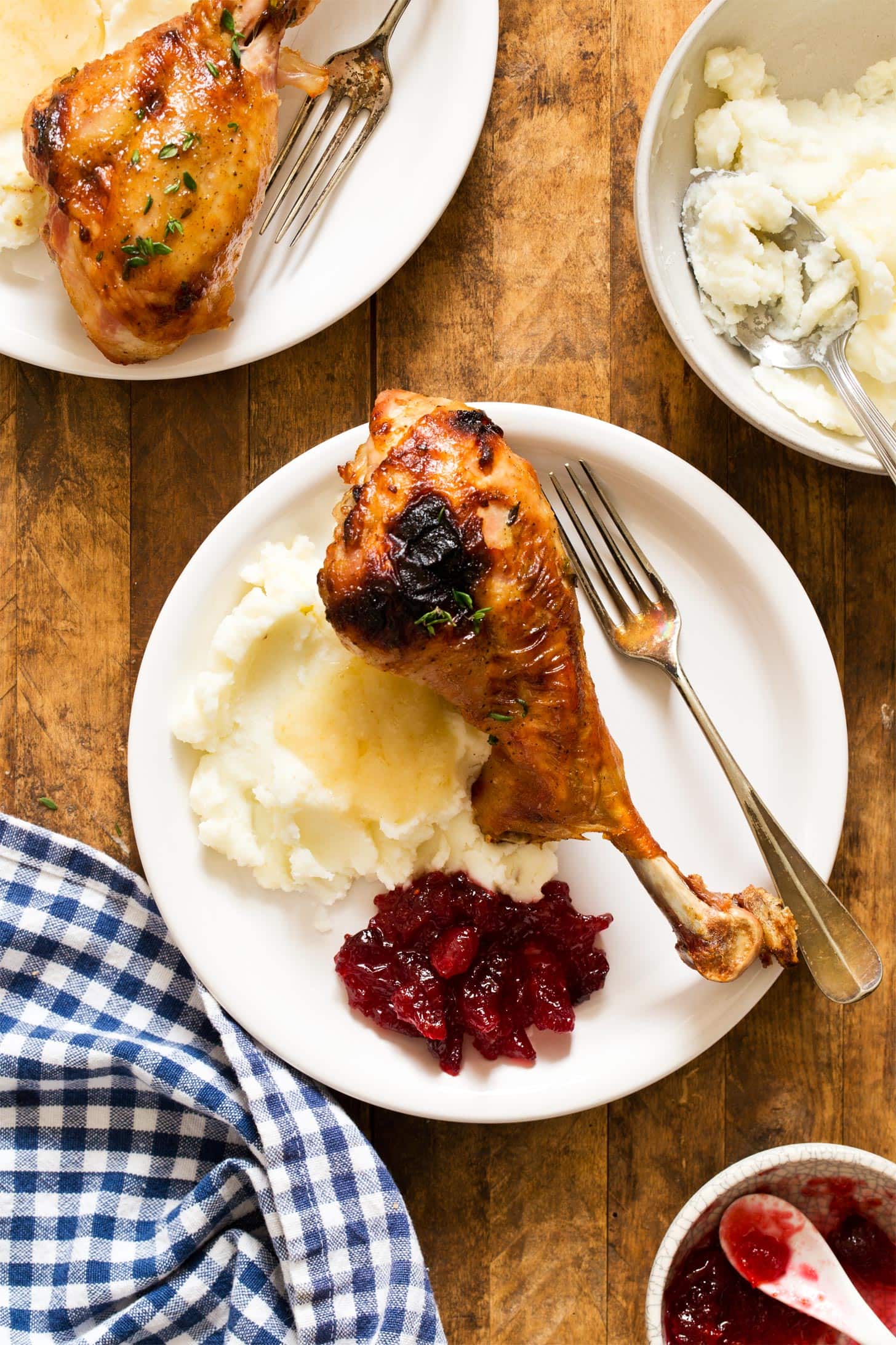 Roasted turkey legs served with mashed potatoes, gravy, and cranberry sauce