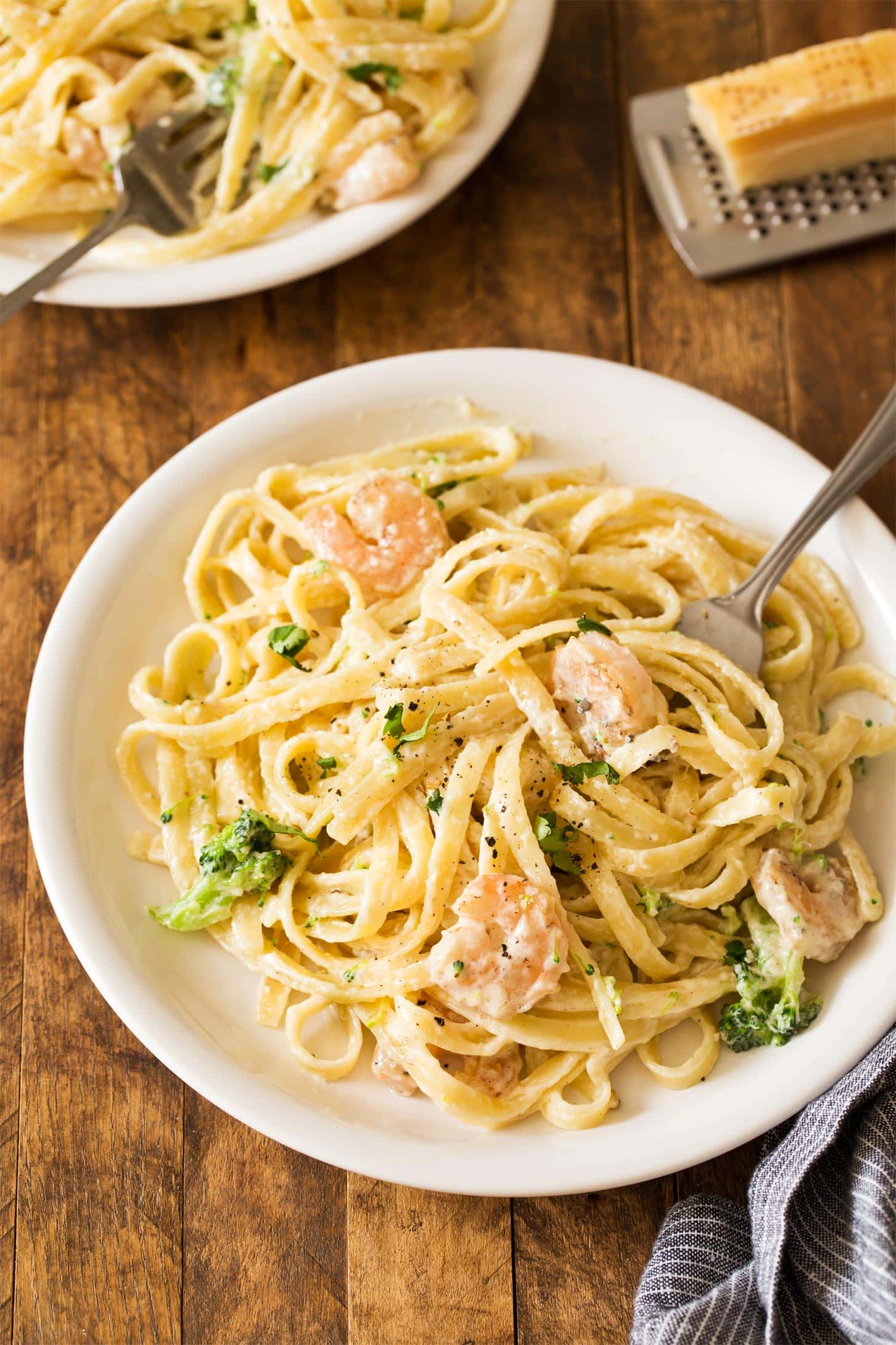 Shrimp Fettuccine Alfredo with broccoli served on white plate