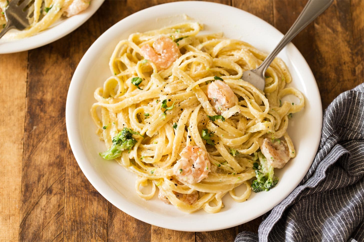 White plate with shrimp and broccoli aflredo