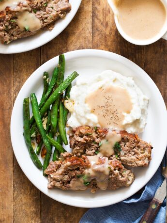 Small meatloaf recipe served with mashed potatoes, gravy, and green beans