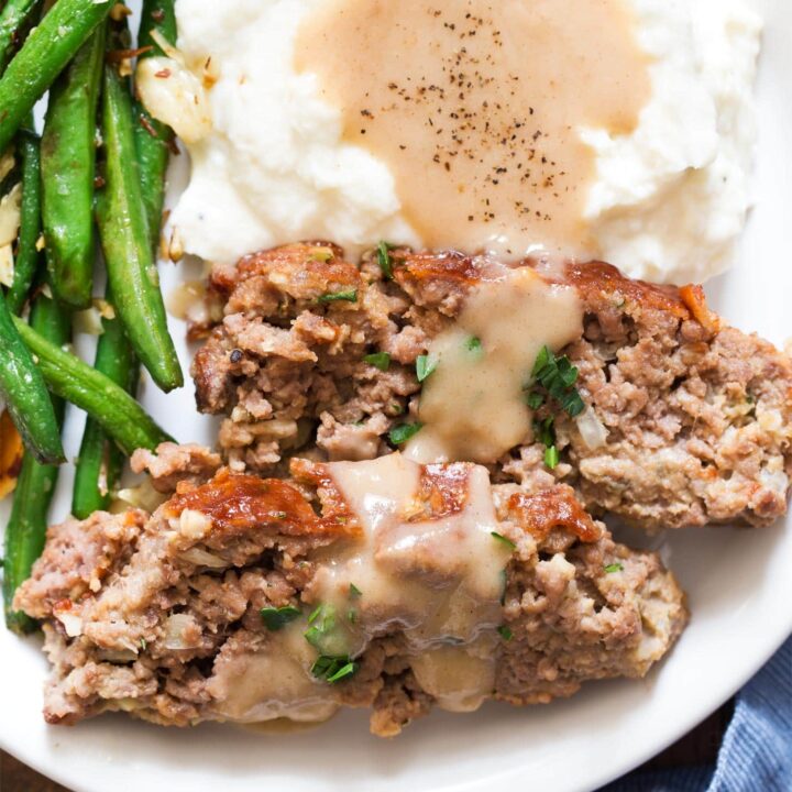 Close up of meatloaf for two with mashed potatoes, gravy, and green beans