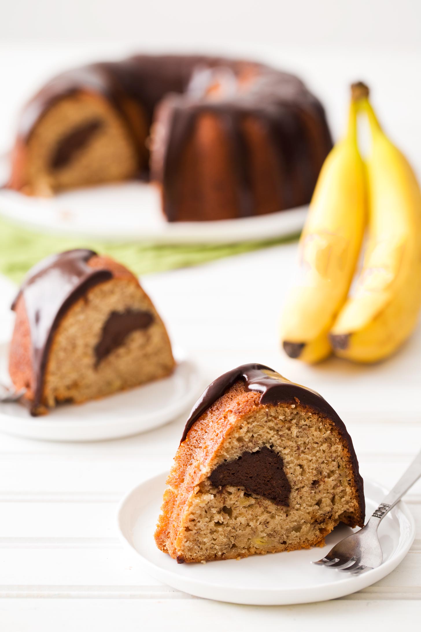 Slices of banana bundt cake with chocolate filling and ganache glaze