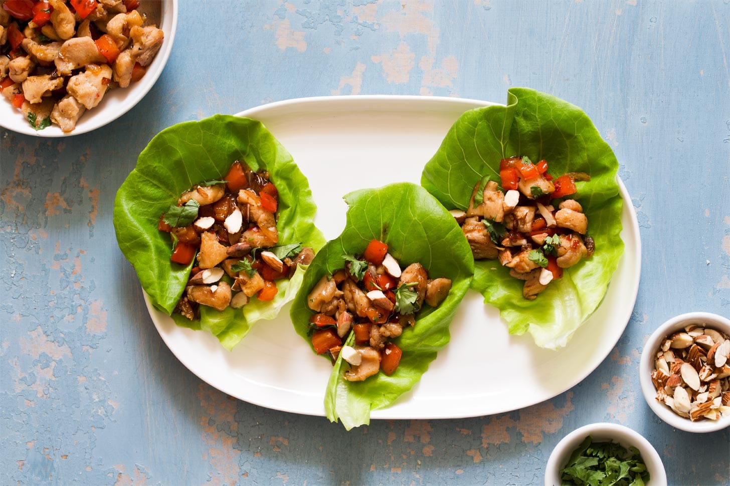 Lettuce wraps with chicken and bell pepper on white plate